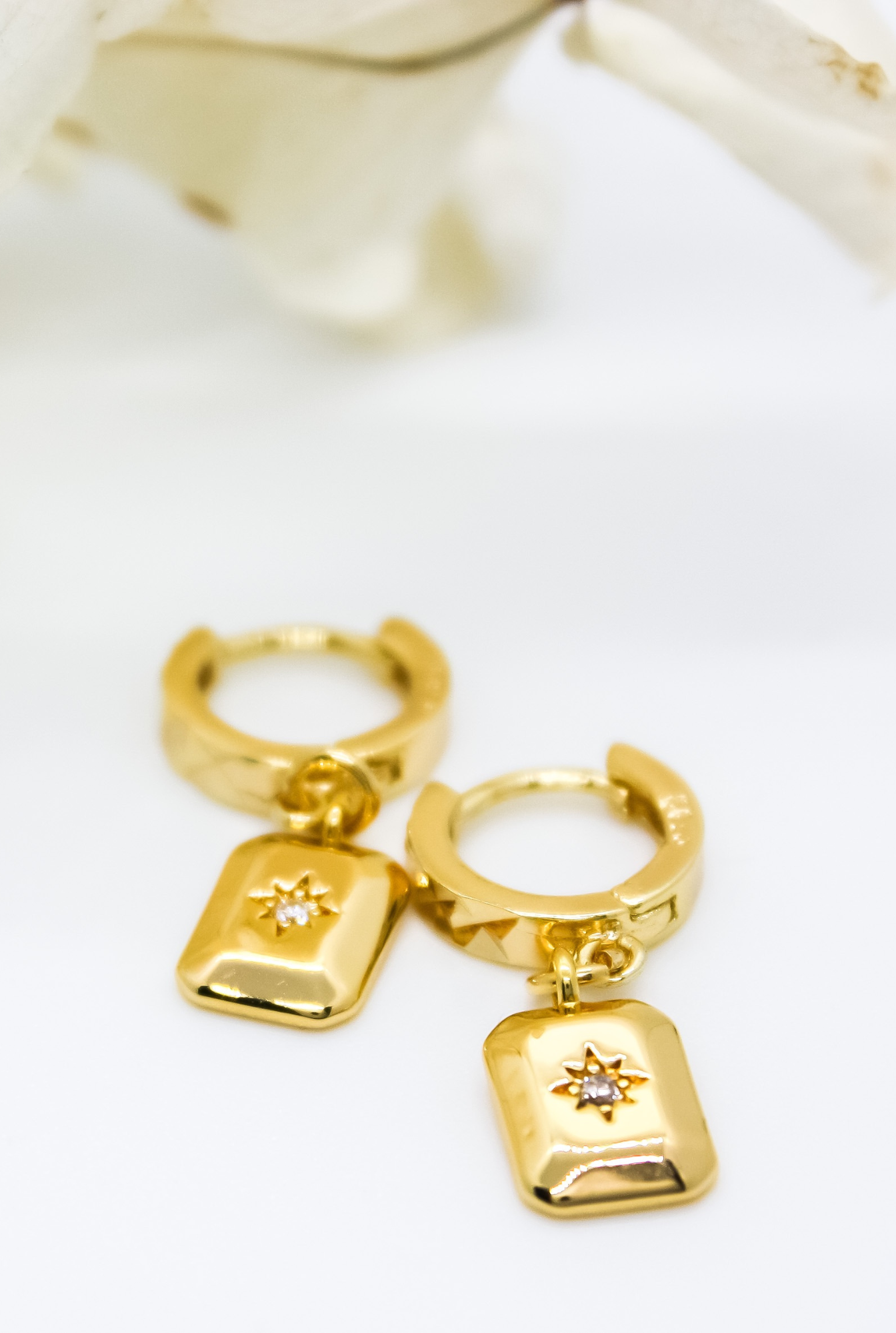 "Gold-filled huggie earrings with classic bohemian design, featuring a rectangle charm with star burst in centre.""